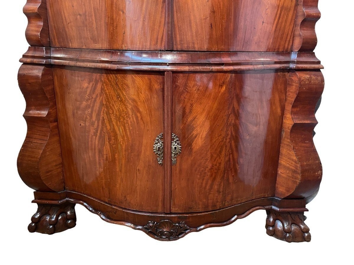 Beautiful large Dutch mahogany corner cupboard from the 18th century. Curved corner cupboard with 4 doors and 4 small drawers inside and standing on large claw feet. The cabinet is in good condition with normal signs of use.