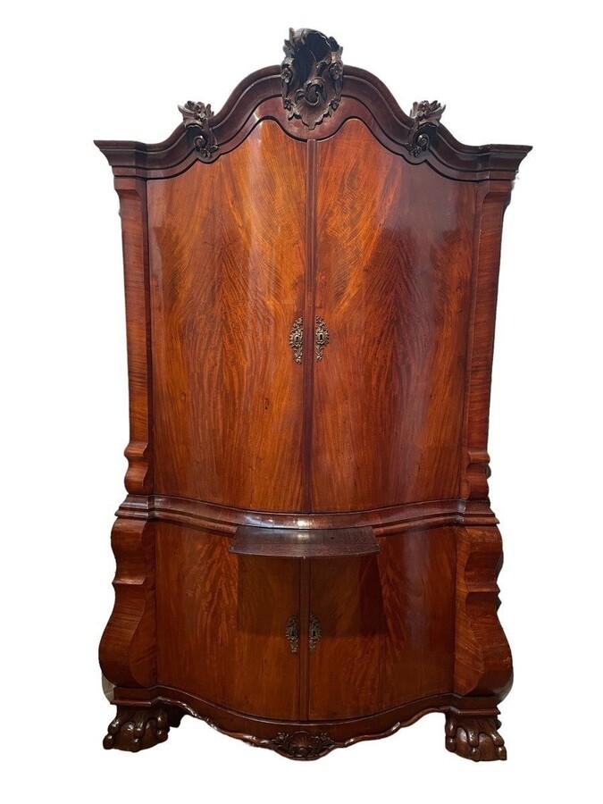 Beautiful large Dutch mahogany corner cupboard from the 18th century. Curved corner cupboard with 4 doors and 4 small drawers inside and standing on large claw feet. The cabinet is in good condition with normal signs of use.