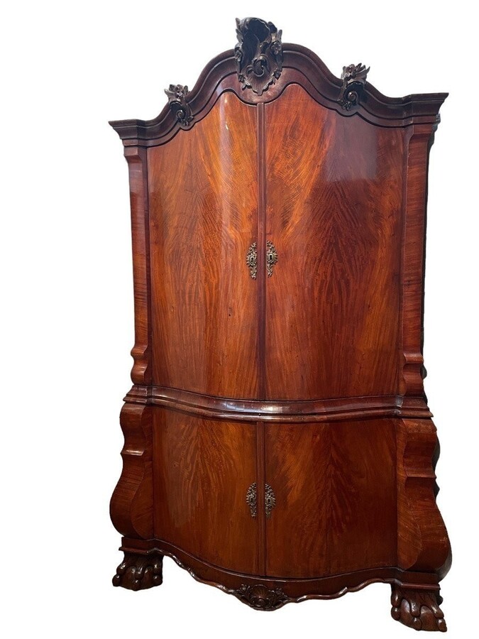 Beautiful large Dutch mahogany corner cupboard from the 18th century. Curved corner cupboard with 4 doors and 4 small drawers inside and standing on large claw feet. The cabinet is in good condition with normal signs of use.