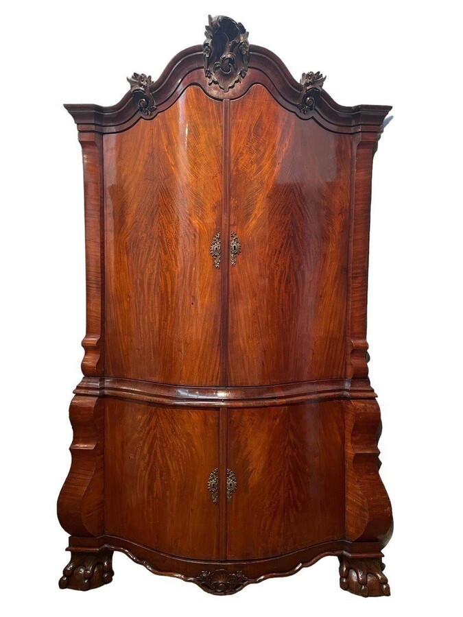 Beautiful large Dutch mahogany corner cupboard from the 18th century. Curved corner cupboard with 4 doors and 4 small drawers inside and standing on large claw feet. The cabinet is in good condition with normal signs of use.
