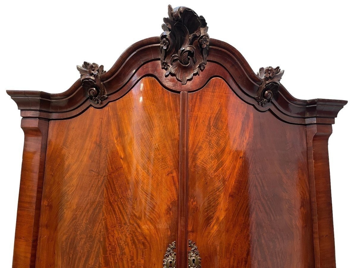 Beautiful large Dutch mahogany corner cupboard from the 18th century. Curved corner cupboard with 4 doors and 4 small drawers inside and standing on large claw feet. The cabinet is in good condition with normal signs of use.