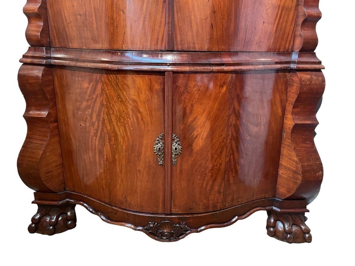 Beautiful large Dutch mahogany corner cupboard from the 18th century. Curved corner cupboard with 4 doors and 4 small drawers inside and standing on large claw feet. The cabinet is in good condition with normal signs of use.