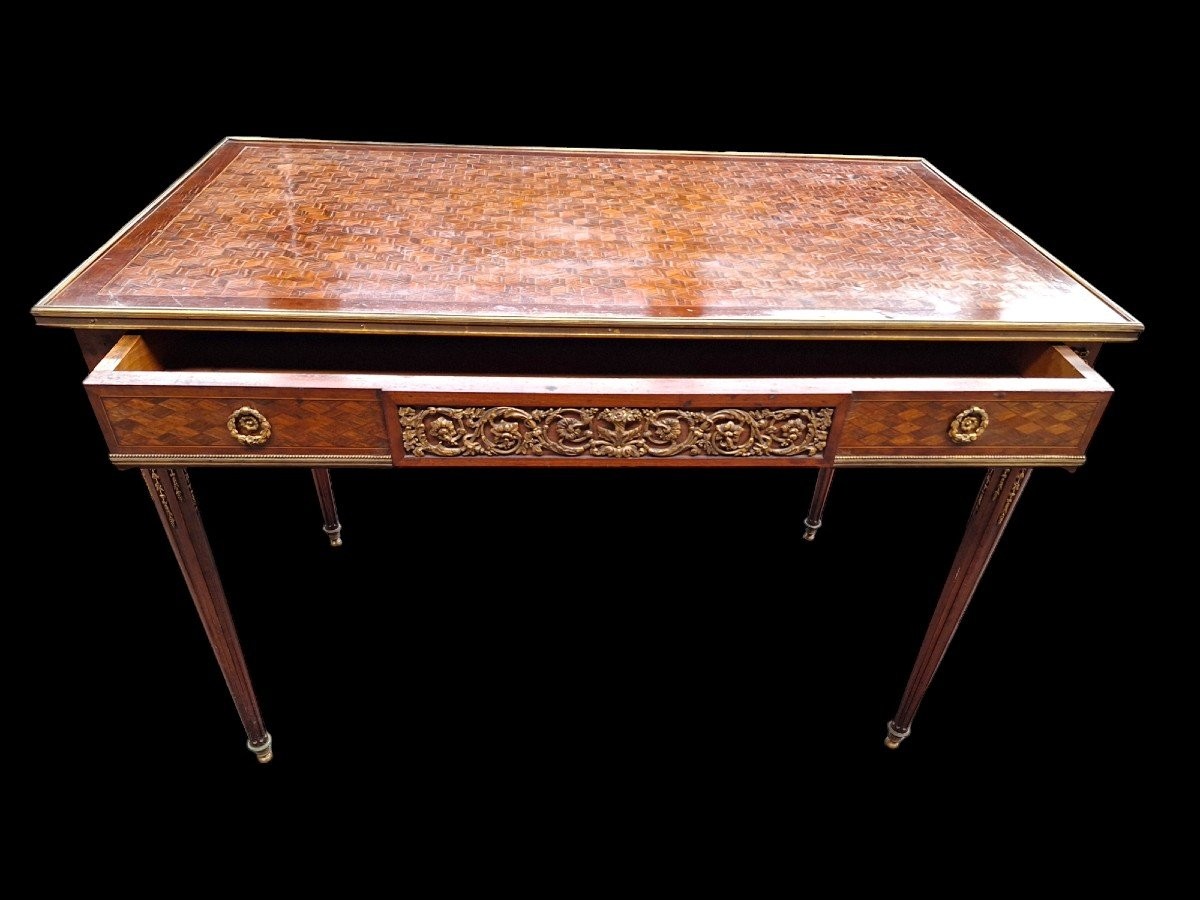Beautiful Louis XVI style coffee table/desk after Jean-Henri Riesener, 19th century. High-quality desk with parquet top, equipped with a large drawer and decorated with very refined bronze decorations and ornaments.