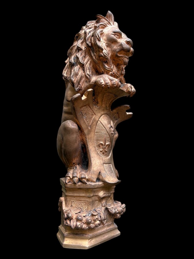 Bronze statuette representing a lion with a coat of arms decorated with a fleur-de-lis, dating from the 19th century. Decorative statuette of French origin dating from the late 19th century. In good condition, the gilding is worn. 