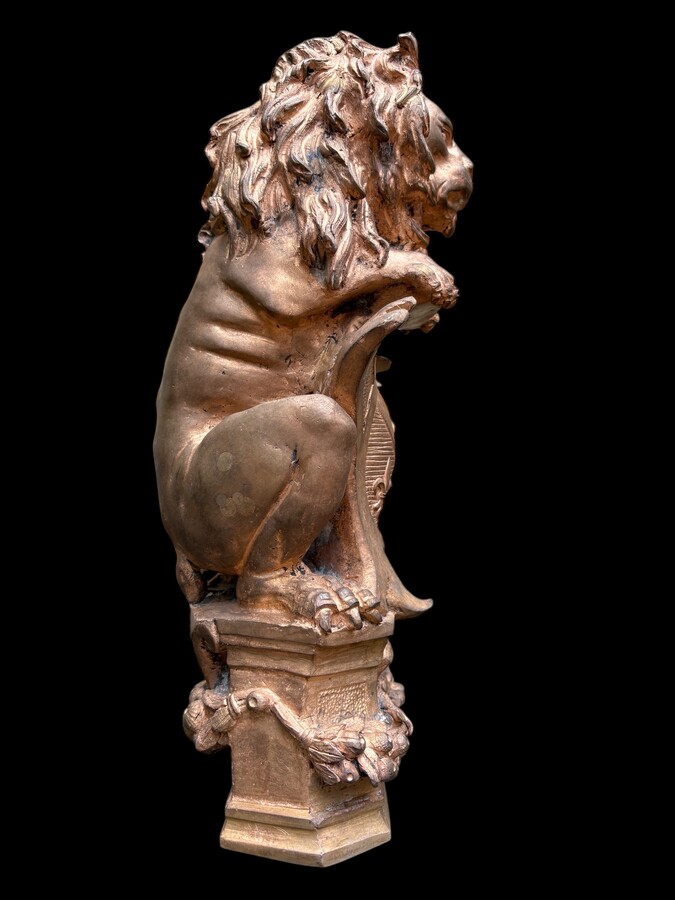 Bronze statuette representing a lion with a coat of arms decorated with a fleur-de-lis, dating from the 19th century. Decorative statuette of French origin dating from the late 19th century. In good condition, the gilding is worn. 