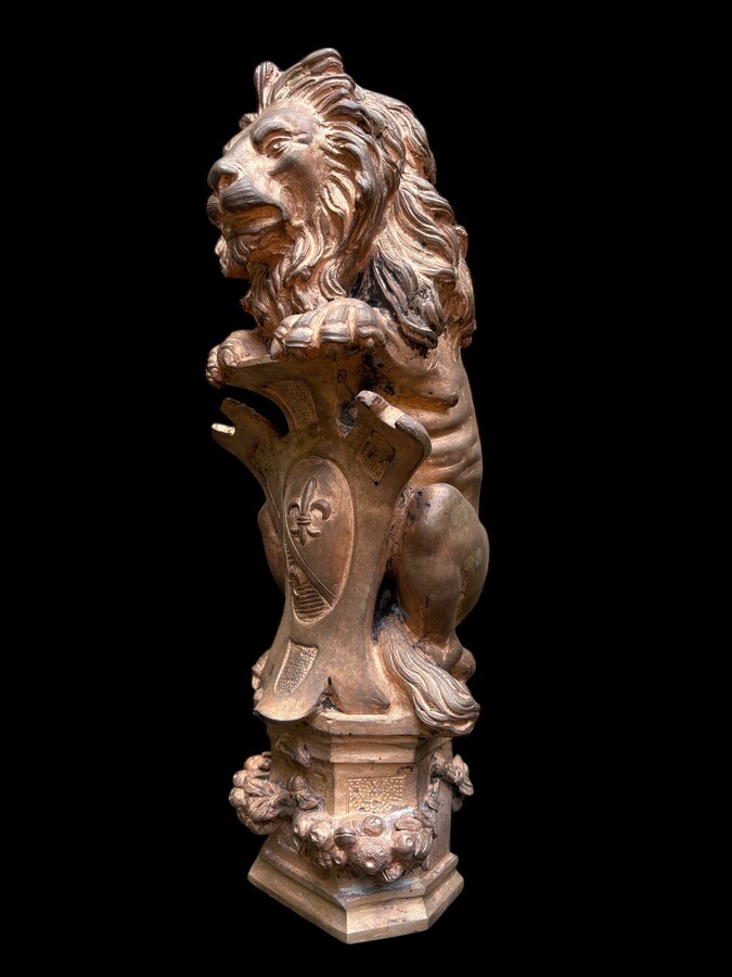 Bronze statuette representing a lion with a coat of arms decorated with a fleur-de-lis, dating from the 19th century. Decorative statuette of French origin dating from the late 19th century. In good condition, the gilding is worn. 