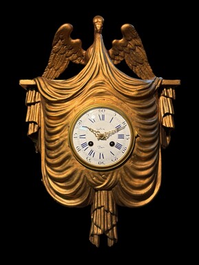 Elegant 19th-century gilt wooden eagle clock with drapery Decorative clock in gilt wood and paste depicting an eagle carrying a large drapery that falls to the left and right of the dial. In normal condition with a few small flaws on the wood.