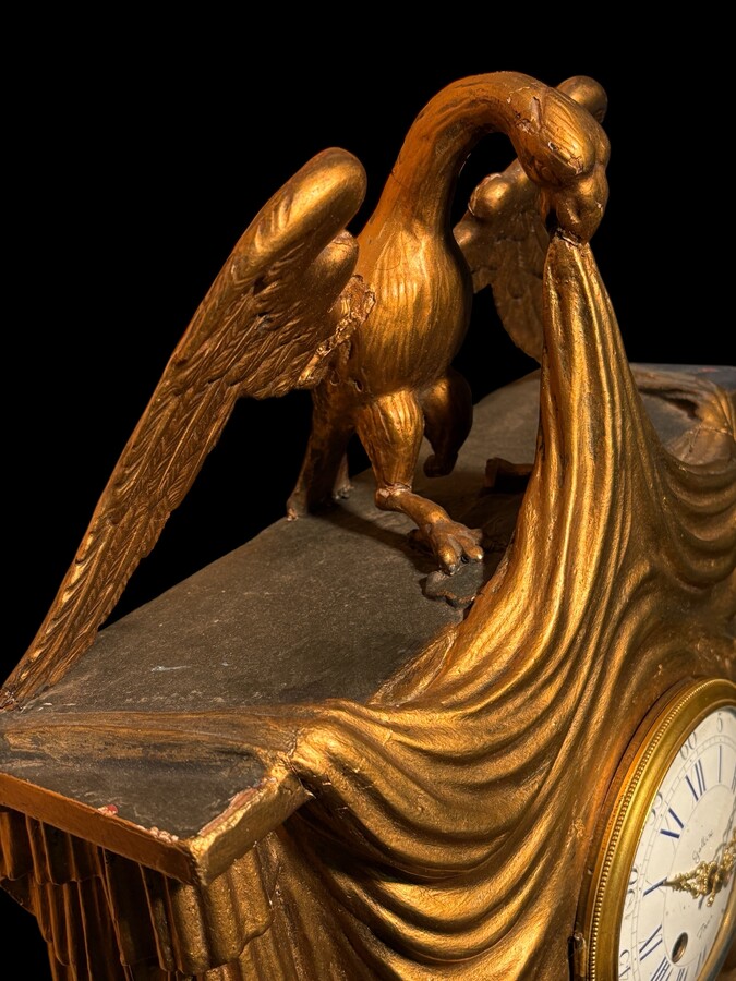 Elegant 19th-century gilt wooden eagle clock with drapery Decorative clock in gilt wood and paste depicting an eagle carrying a large drapery that falls to the left and right of the dial. In normal condition with a few small flaws on the wood.