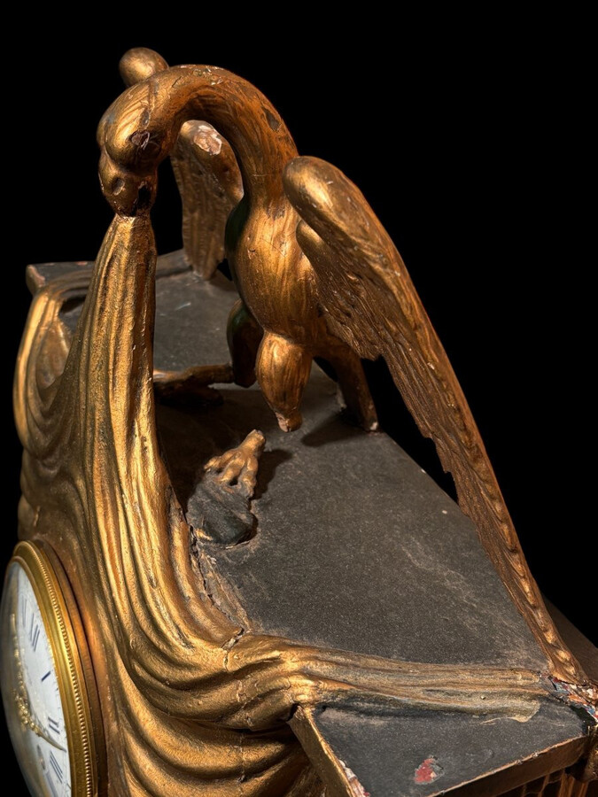 Elegant 19th-century gilt wooden eagle clock with drapery Decorative clock in gilt wood and paste depicting an eagle carrying a large drapery that falls to the left and right of the dial. In normal condition with a few small flaws on the wood.