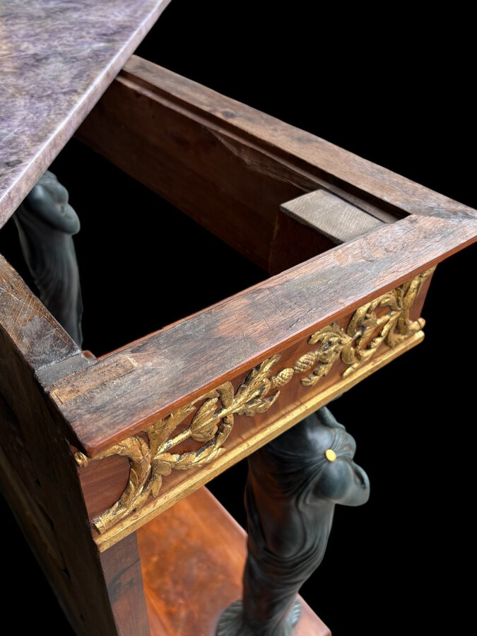 Elegant Empire-style mahogany console table, 19th century. Decorative Empire-style console table adorned with two large patinated female figures, gilded decorations, a mirror at the back and a special marble top.