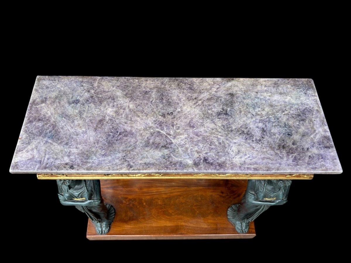 Elegant Empire-style mahogany console table, 19th century. Decorative Empire-style console table adorned with two large patinated female figures, gilded decorations, a mirror at the back and a special marble top.