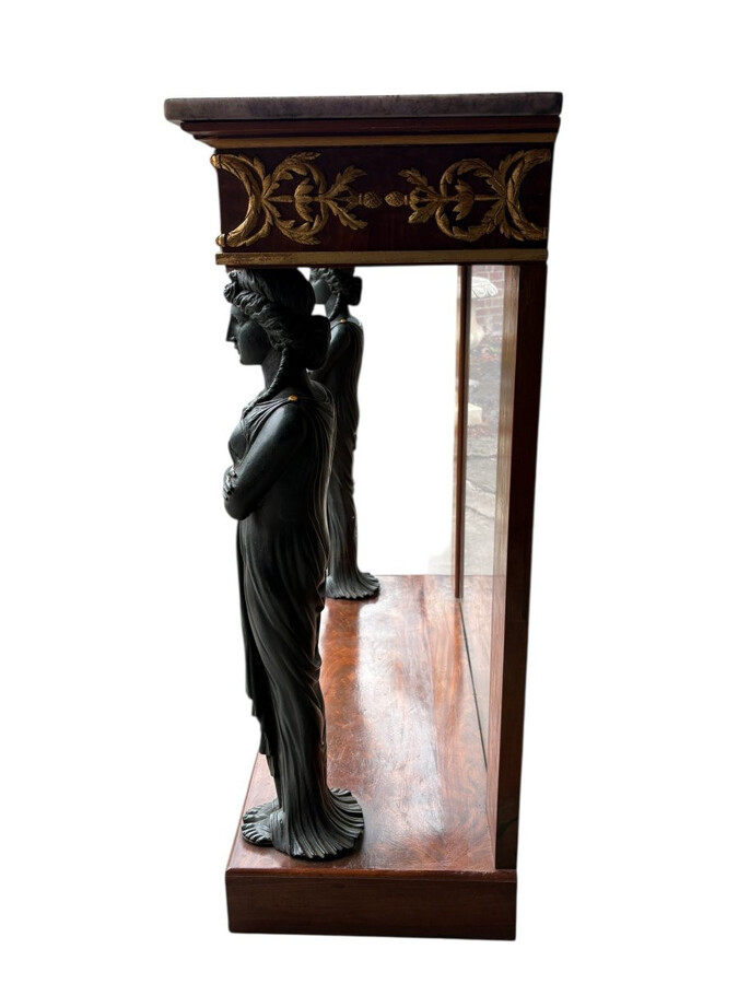 Elegant Empire-style mahogany console table, 19th century. Decorative Empire-style console table adorned with two large patinated female figures, gilded decorations, a mirror at the back and a special marble top.