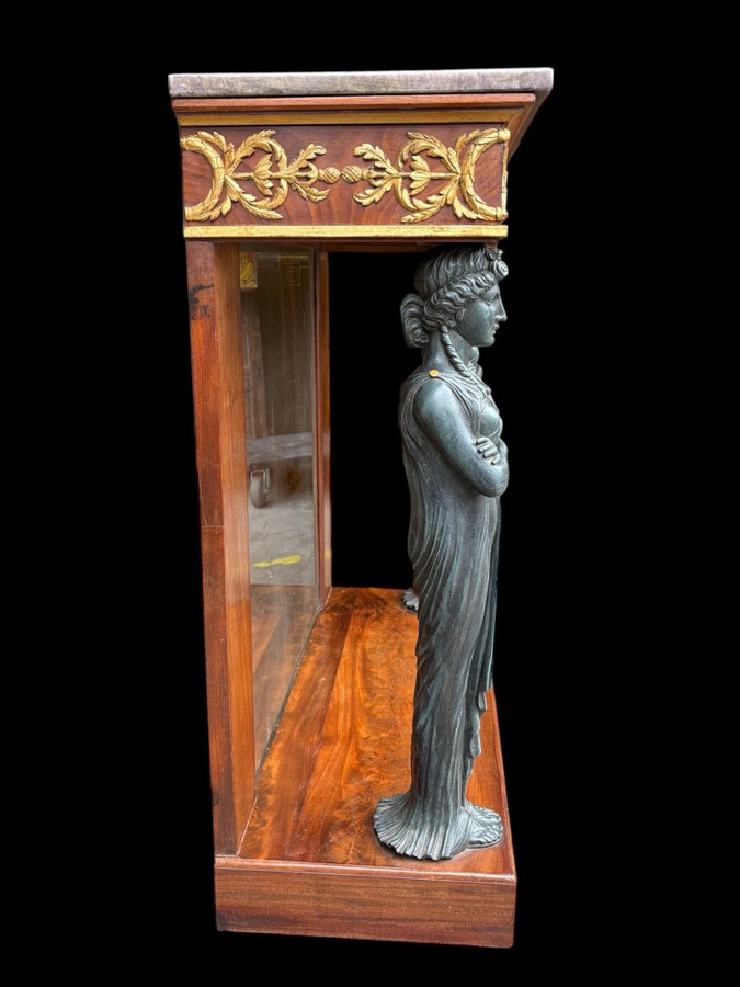 Elegant Empire-style mahogany console table, 19th century. Decorative Empire-style console table adorned with two large patinated female figures, gilded decorations, a mirror at the back and a special marble top.