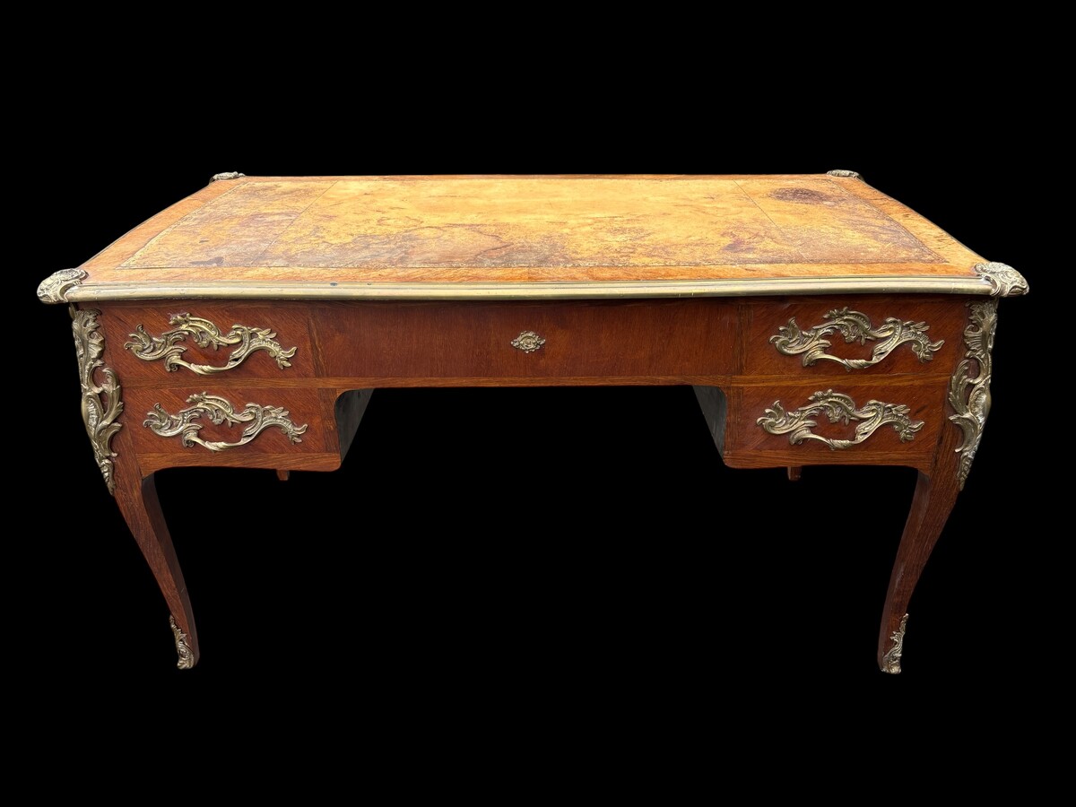 Elegant Louis XV-style veneered wooden desk, 1900 The desk features 5 drawers, bronze fittings and decorations, and a brown leather top. The desk is in good condition but requires refurbishment. Dimensions: Width: 140 cm Height: 76 cm