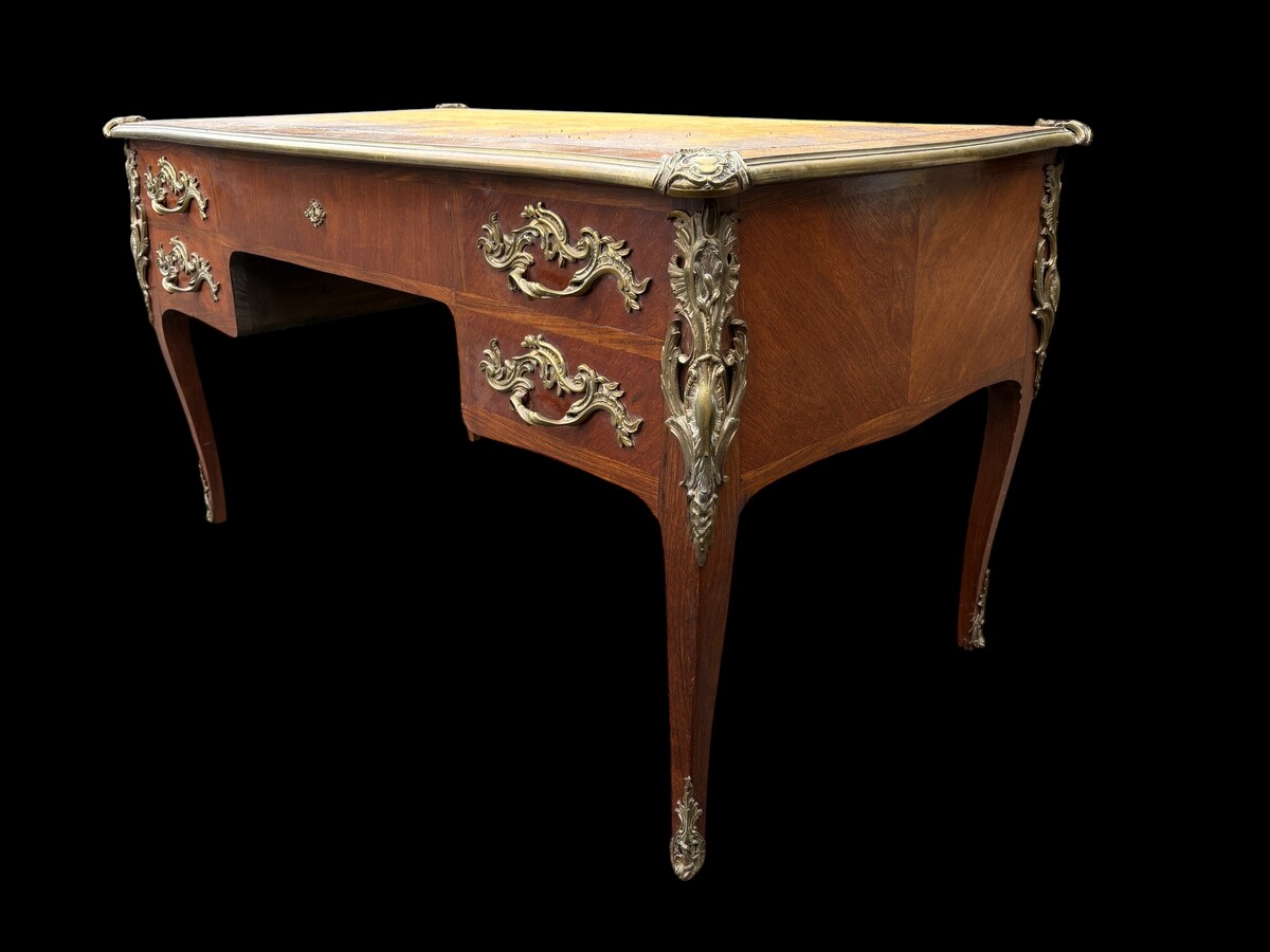 Elegant Louis XV-style veneered wooden desk, 1900 The desk features 5 drawers, bronze fittings and decorations, and a brown leather top. The desk is in good condition but requires refurbishment. Dimensions: Width: 140 cm Height: 76 cm
