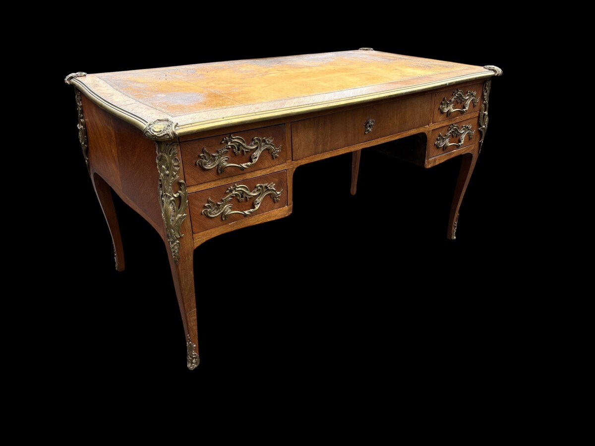 Elegant Louis XV-style veneered wooden desk, 1900 The desk features 5 drawers, bronze fittings and decorations, and a brown leather top. The desk is in good condition but requires refurbishment. Dimensions: Width: 140 cm Height: 76 cm
