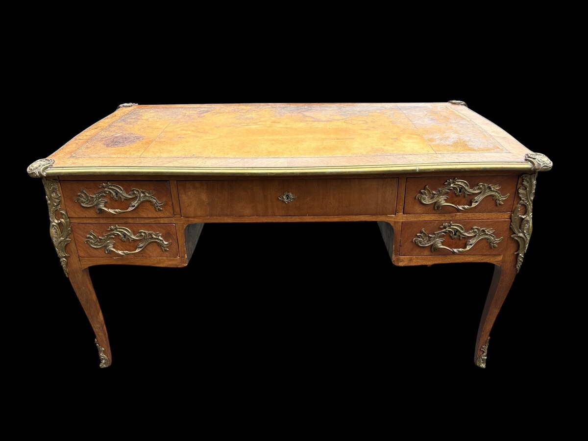 Elegant Louis XV-style veneered wooden desk, 1900 The desk features 5 drawers, bronze fittings and decorations, and a brown leather top. The desk is in good condition but requires refurbishment. Dimensions: Width: 140 cm Height: 76 cm
