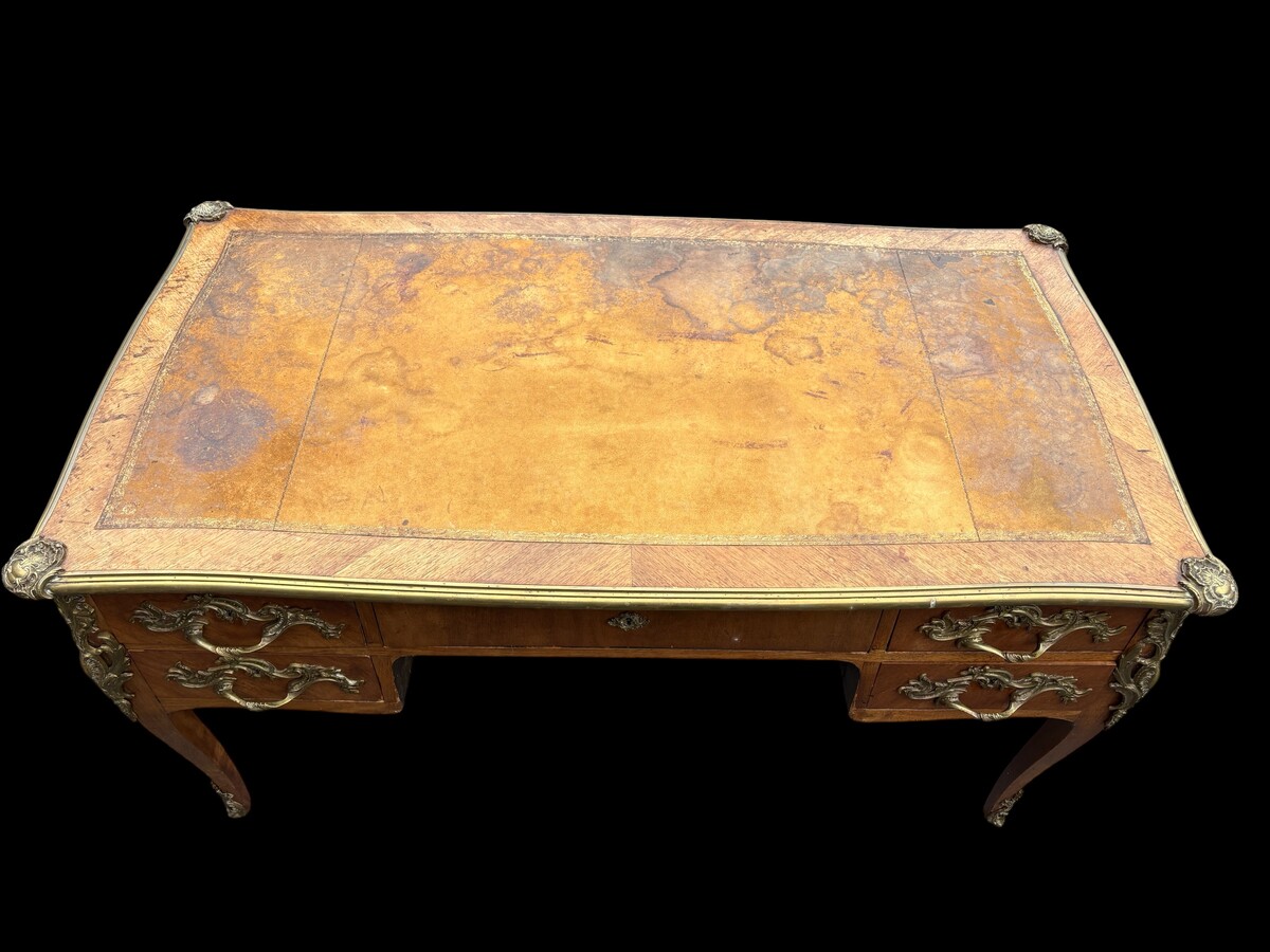Elegant Louis XV-style veneered wooden desk, 1900 The desk features 5 drawers, bronze fittings and decorations, and a brown leather top. The desk is in good condition but requires refurbishment. Dimensions: Width: 140 cm Height: 76 cm