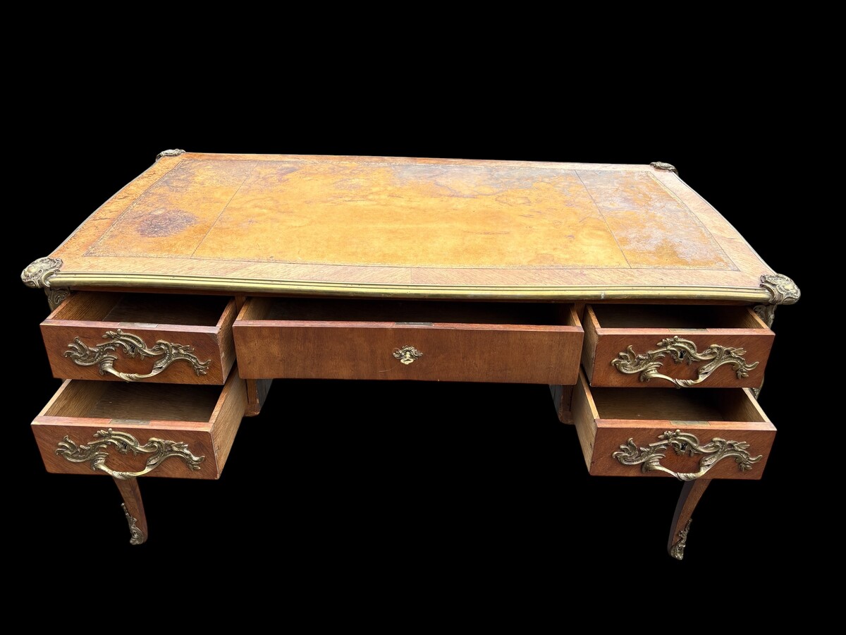 Elegant Louis XV-style veneered wooden desk, 1900 The desk features 5 drawers, bronze fittings and decorations, and a brown leather top. The desk is in good condition but requires refurbishment. Dimensions: Width: 140 cm Height: 76 cm