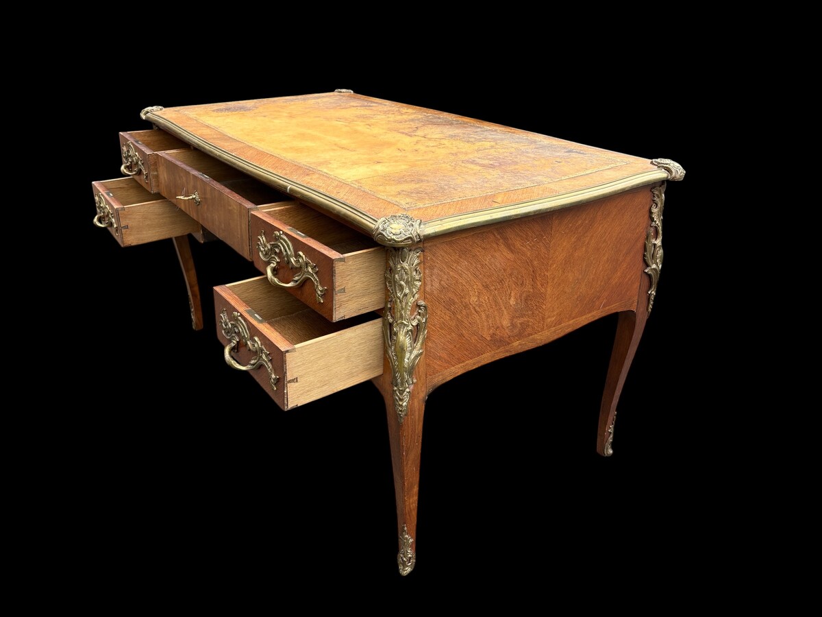 Elegant Louis XV-style veneered wooden desk, 1900 The desk features 5 drawers, bronze fittings and decorations, and a brown leather top. The desk is in good condition but requires refurbishment. Dimensions: Width: 140 cm Height: 76 cm