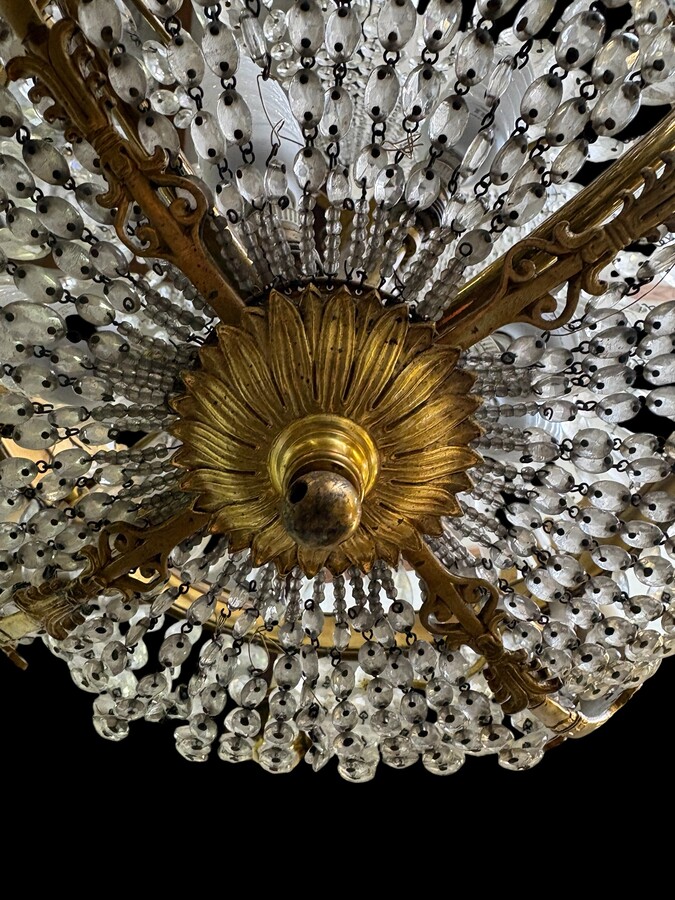 Empire-style chandelier Lighting provided by 8 inner lights and a ring of 8 outer lights. Beautiful gilded bronze frame. In good condition, with a few crystals missing. A lovely chandelier, made in France, 