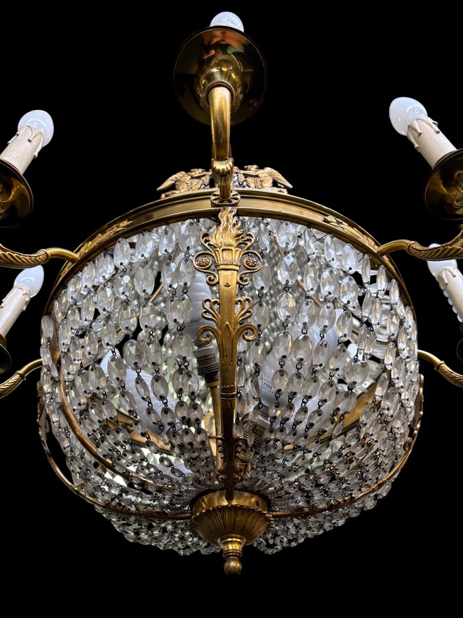 Empire-style chandelier Lighting provided by 8 inner lights and a ring of 8 outer lights. Beautiful gilded bronze frame. In good condition, with a few crystals missing. A lovely chandelier, made in France, 