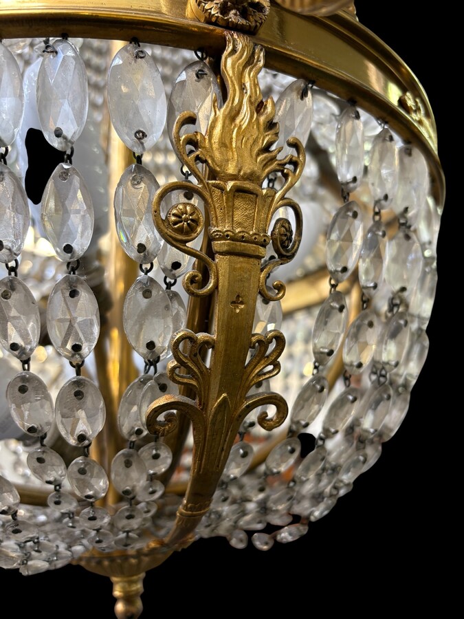 Empire-style chandelier Lighting provided by 8 inner lights and a ring of 8 outer lights. Beautiful gilded bronze frame. In good condition, with a few crystals missing. A lovely chandelier, made in France, 