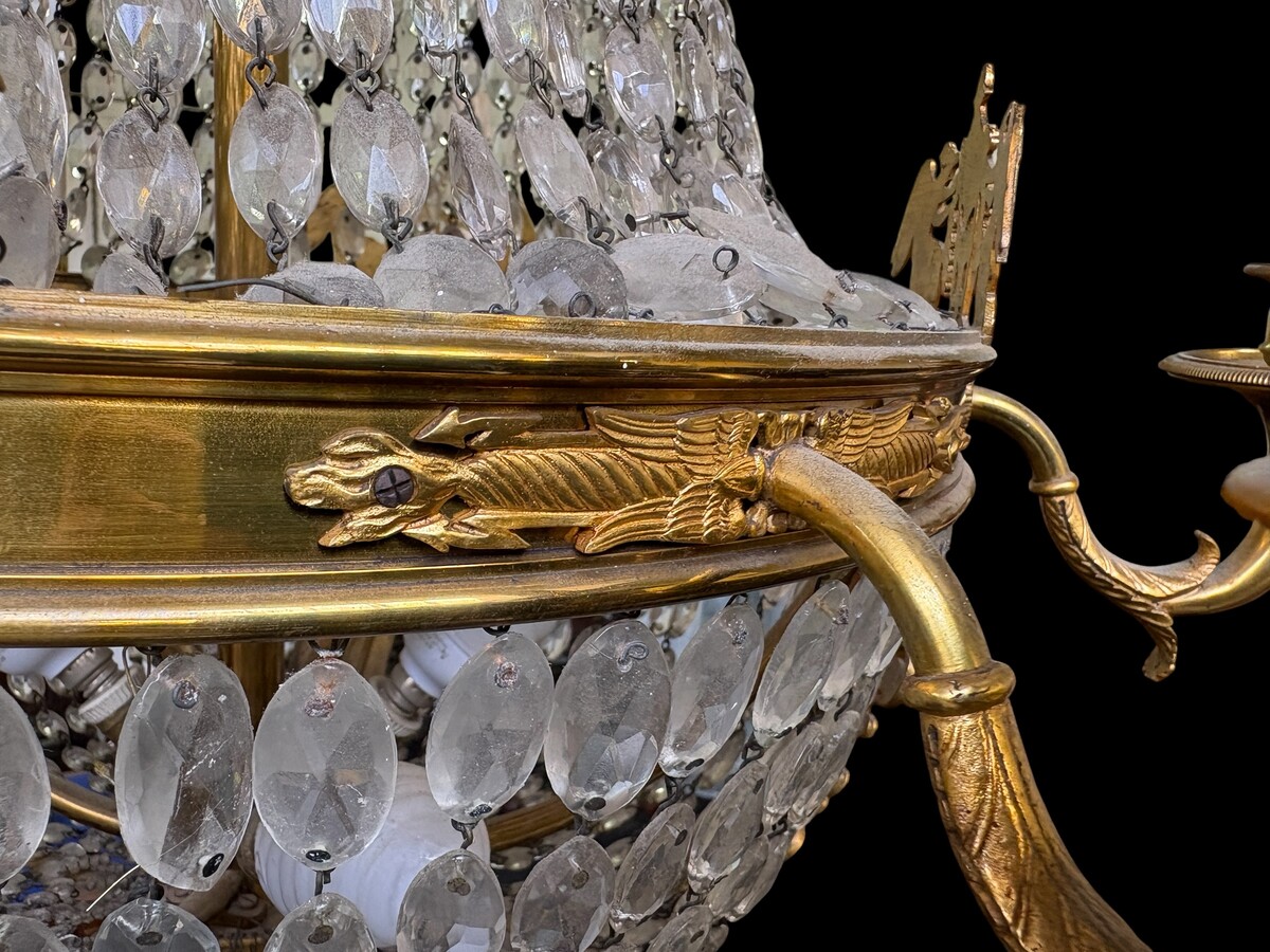 Empire-style chandelier Lighting provided by 8 inner lights and a ring of 8 outer lights. Beautiful gilded bronze frame. In good condition, with a few crystals missing. A lovely chandelier, made in France, 