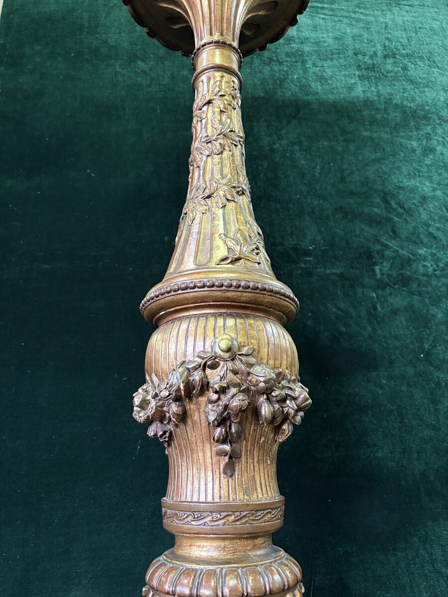 Large 19th-century gilded wooden candelabra (163 cm) Decorative candelabra with a stem, adorned with motifs, tendrils, garlands, French lilies, drapery and tassels, resting on three large legs decorated with mythological fish and scrolls.