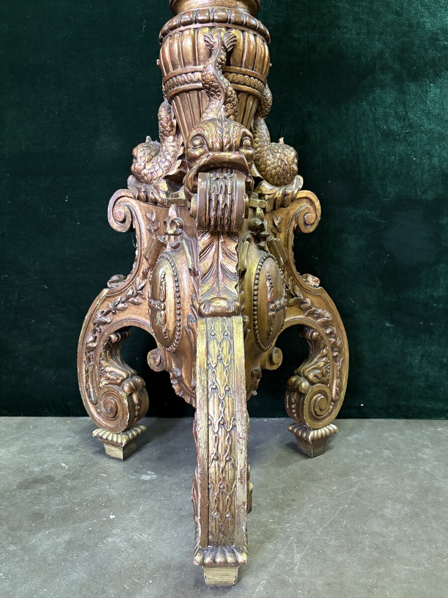 Large 19th-century gilded wooden candelabra (163 cm) Decorative candelabra with a stem, adorned with motifs, tendrils, garlands, French lilies, drapery and tassels, resting on three large legs decorated with mythological fish and scrolls.
