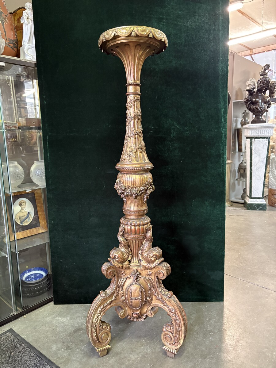 Large 19th-century gilded wooden candelabra (163 cm) Decorative candelabra with a stem, adorned with motifs, tendrils, garlands, French lilies, drapery and tassels, resting on three large legs decorated with mythological fish and scrolls.