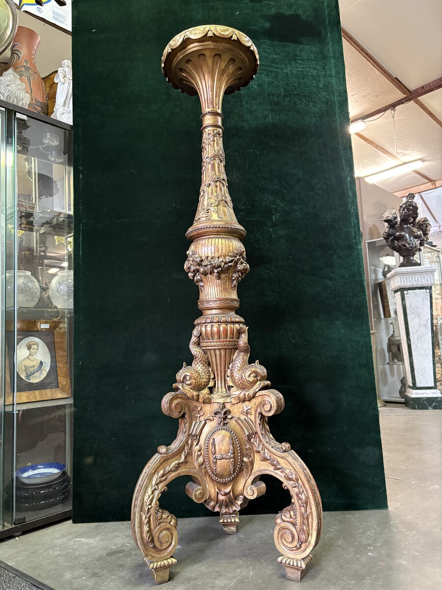 Large 19th-century gilded wooden candelabra (163 cm) Decorative candelabra with a stem, adorned with motifs, tendrils, garlands, French lilies, drapery and tassels, resting on three large legs decorated with mythological fish and scrolls.