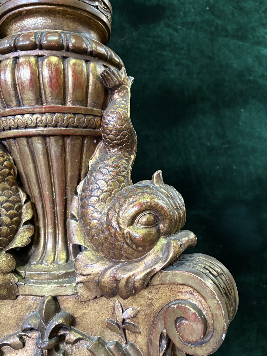 Large 19th-century gilded wooden candelabra (163 cm) Decorative candelabra with a stem, adorned with motifs, tendrils, garlands, French lilies, drapery and tassels, resting on three large legs decorated with mythological fish and scrolls.