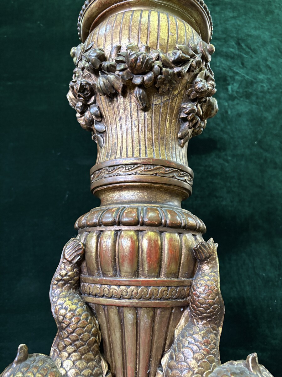 Large 19th-century gilded wooden candelabra (163 cm) Decorative candelabra with a stem, adorned with motifs, tendrils, garlands, French lilies, drapery and tassels, resting on three large legs decorated with mythological fish and scrolls.