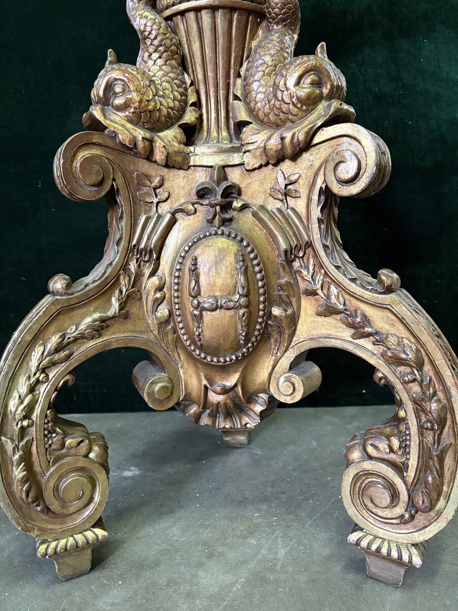 Large 19th-century gilded wooden candelabra (163 cm) Decorative candelabra with a stem, adorned with motifs, tendrils, garlands, French lilies, drapery and tassels, resting on three large legs decorated with mythological fish and scrolls.