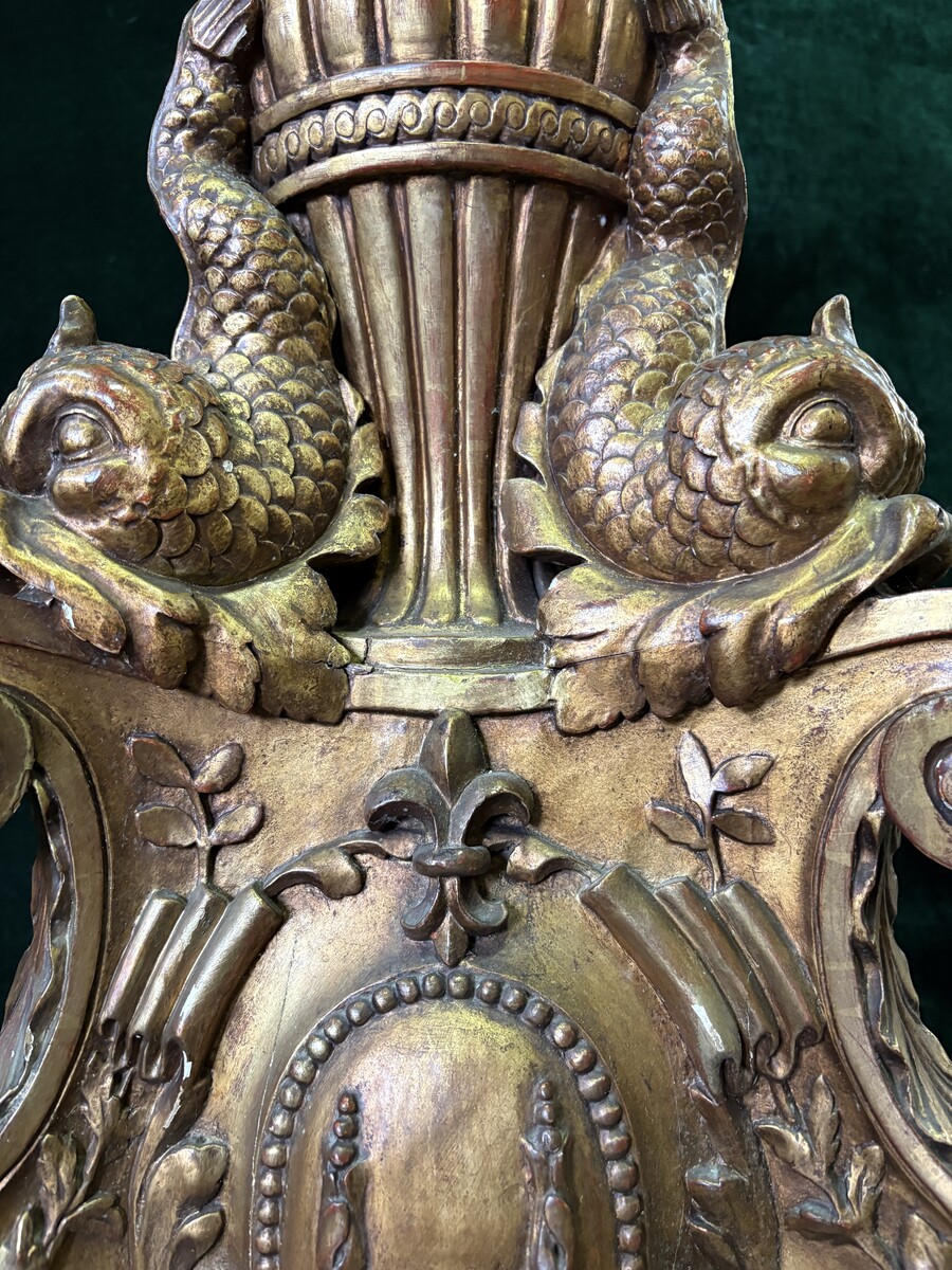 Large 19th-century gilded wooden candelabra (163 cm) Decorative candelabra with a stem, adorned with motifs, tendrils, garlands, French lilies, drapery and tassels, resting on three large legs decorated with mythological fish and scrolls.