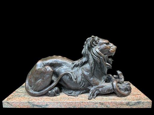 Large bronze sculpture of a lion lying down with its prey, 19th century. Finely detailed decorative bronze sculpture of a lion fighting a snake. The bronze is mounted on a marble base. Dimensions: Bronze width: 46 cm Height: 26 cm Depth: 19 cm Marble base