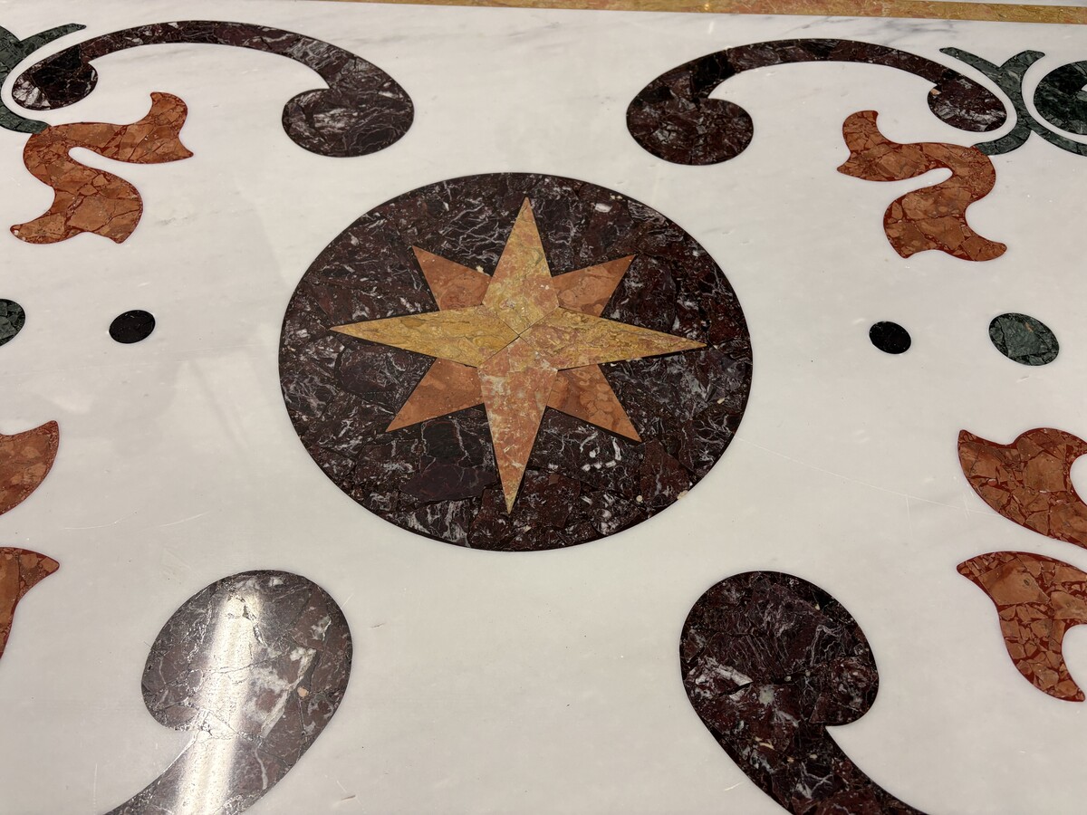 Large decorative table with an inlaid marble top, 20th century A beautiful table featuring a wrought-iron base topped with a marble top inlaid with various types and colours of marble, with a large star in the centre. Dimensions: 200 x 100 x 74 cm