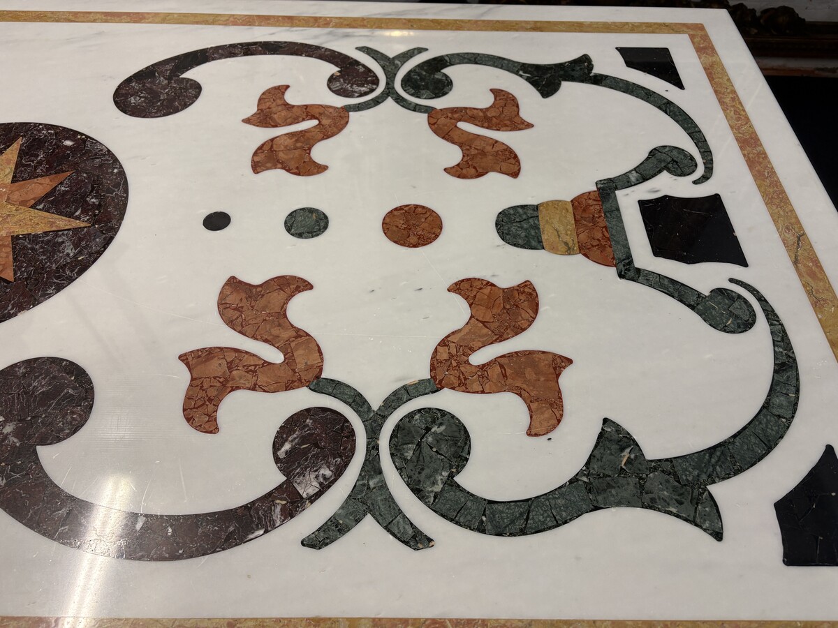 Large decorative table with an inlaid marble top, 20th century A beautiful table featuring a wrought-iron base topped with a marble top inlaid with various types and colours of marble, with a large star in the centre. Dimensions: 200 x 100 x 74 cm