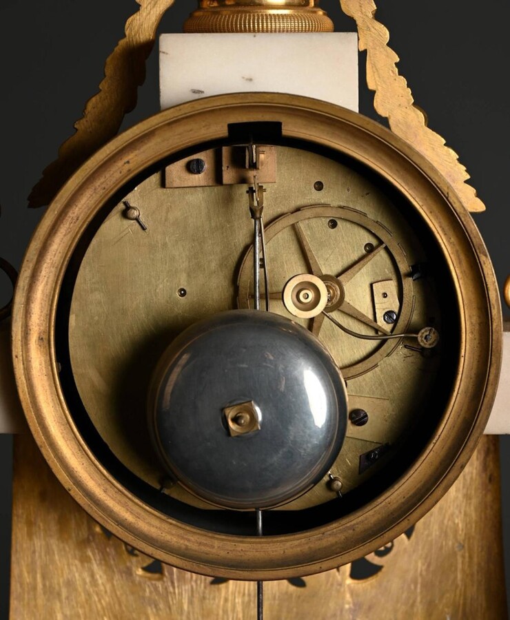 Large Empire-style portico clock (64.5 cm), 19thC. Large clock featuring two marble columns adorned with two caryatids, rosettes, drapery, decorative motifs, two patinated and gilded sphinxes, and an eagle at the top. Sun dial and key included; move