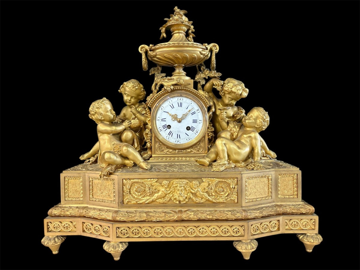 Large gilt bronze clock set. Paris, 19th century. A beautiful large clock with four cherubs and very fine gilt bronze decorations, as well as two candlesticks representing two large cherubs carrying a torch with six candlesticks.