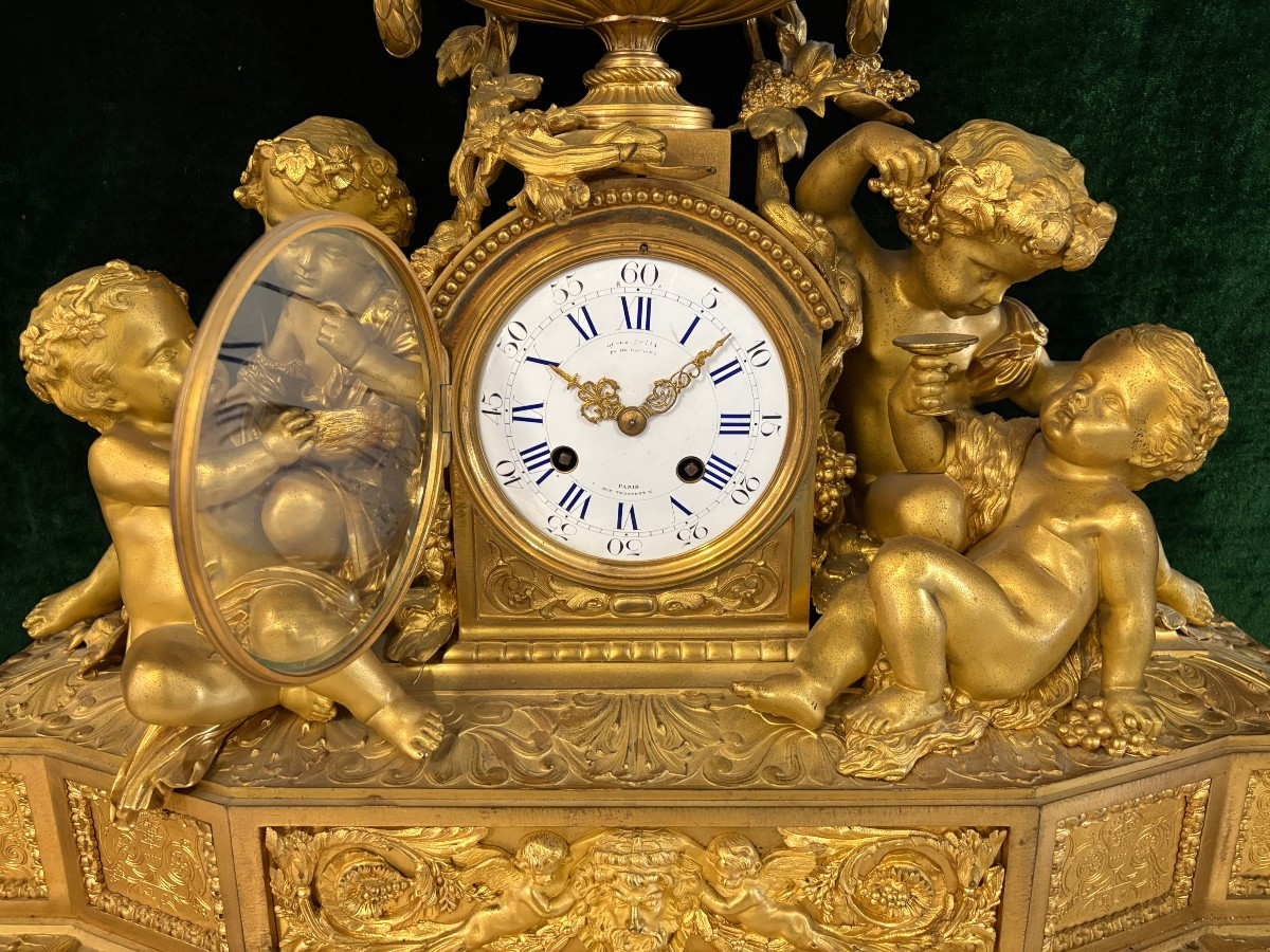 Large gilt bronze clock set. Paris, 19th century. A beautiful large clock with four cherubs and very fine gilt bronze decorations, as well as two candlesticks representing two large cherubs carrying a torch with six candlesticks.