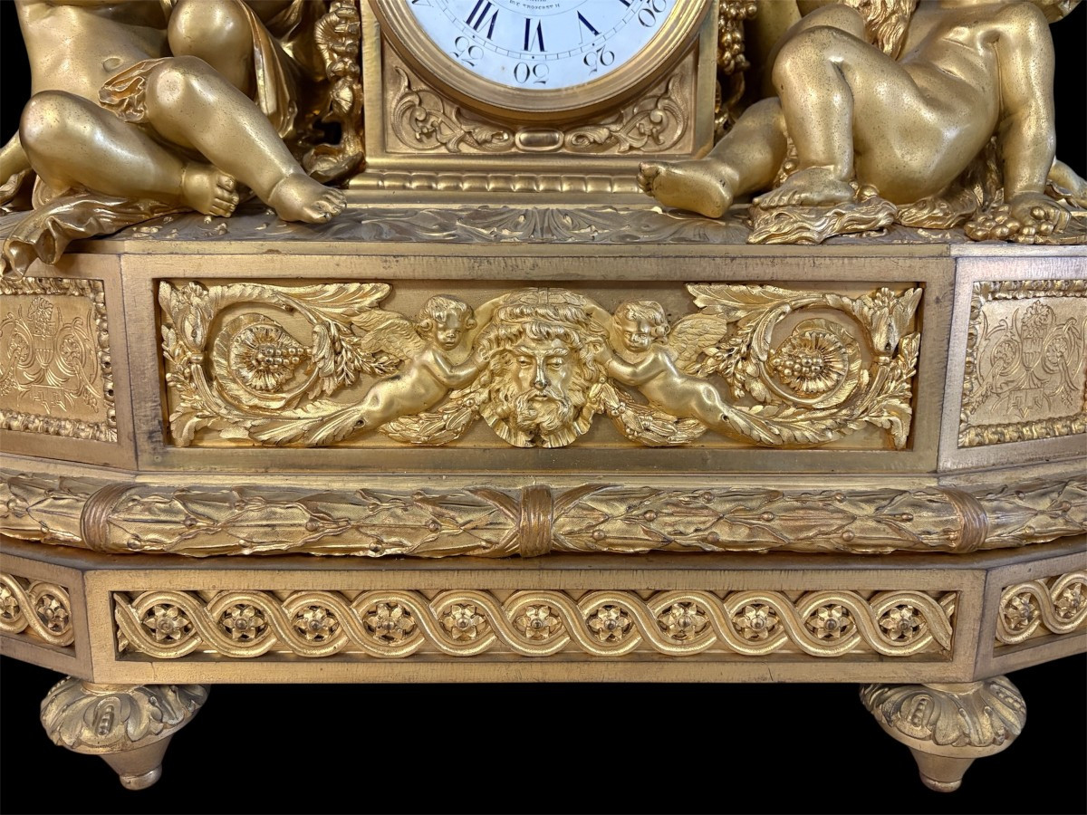 Large gilt bronze clock set. Paris, 19th century. A beautiful large clock with four cherubs and very fine gilt bronze decorations, as well as two candlesticks representing two large cherubs carrying a torch with six candlesticks.