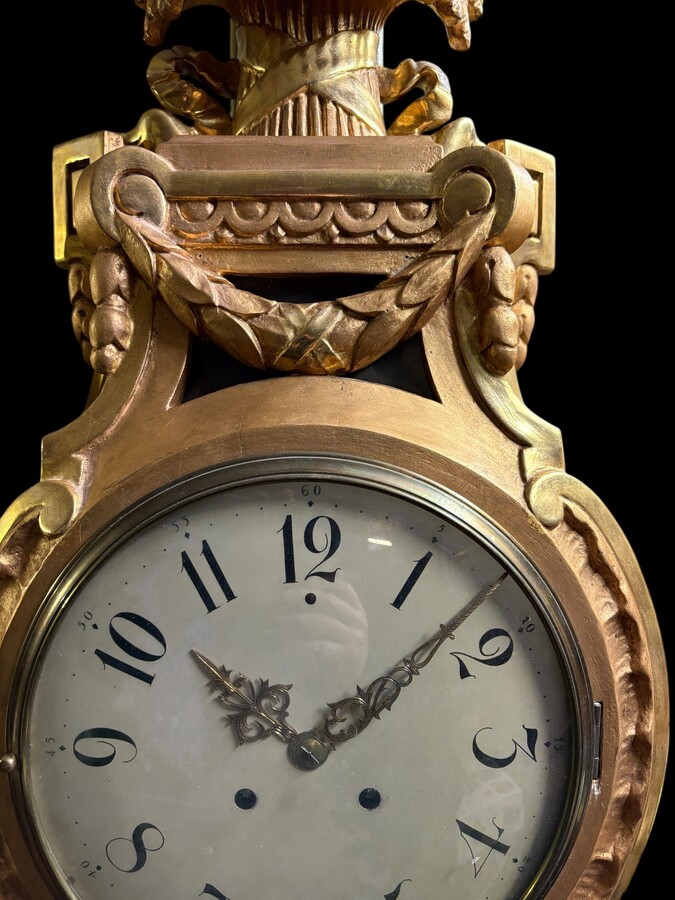 Large Swedish clock in gilded wood, Louis XVI style, 19th century Highly decorative clock in matt and shiny gold. Dimensions: Height: 97 cm Width: 49 cm Depth: 13 cm Key and pendulum present, mechanism to be checked. Attractive Swedish clock, circa 1860-1
