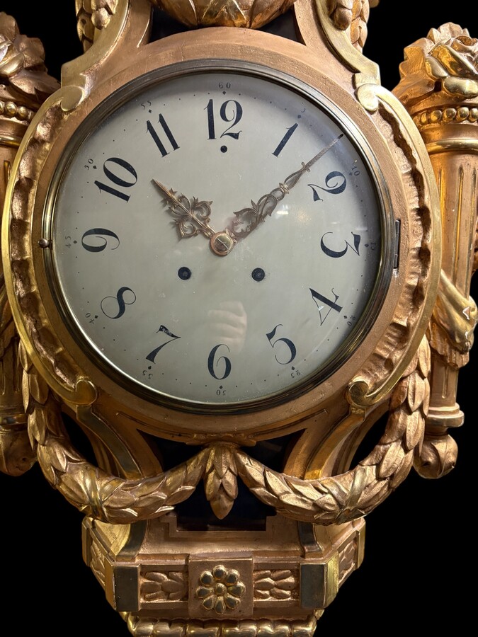 Large Swedish clock in gilded wood, Louis XVI style, 19th century Highly decorative clock in matt and shiny gold. Dimensions: Height: 97 cm Width: 49 cm Depth: 13 cm Key and pendulum present, mechanism to be checked. Attractive Swedish clock, circa 1860-1