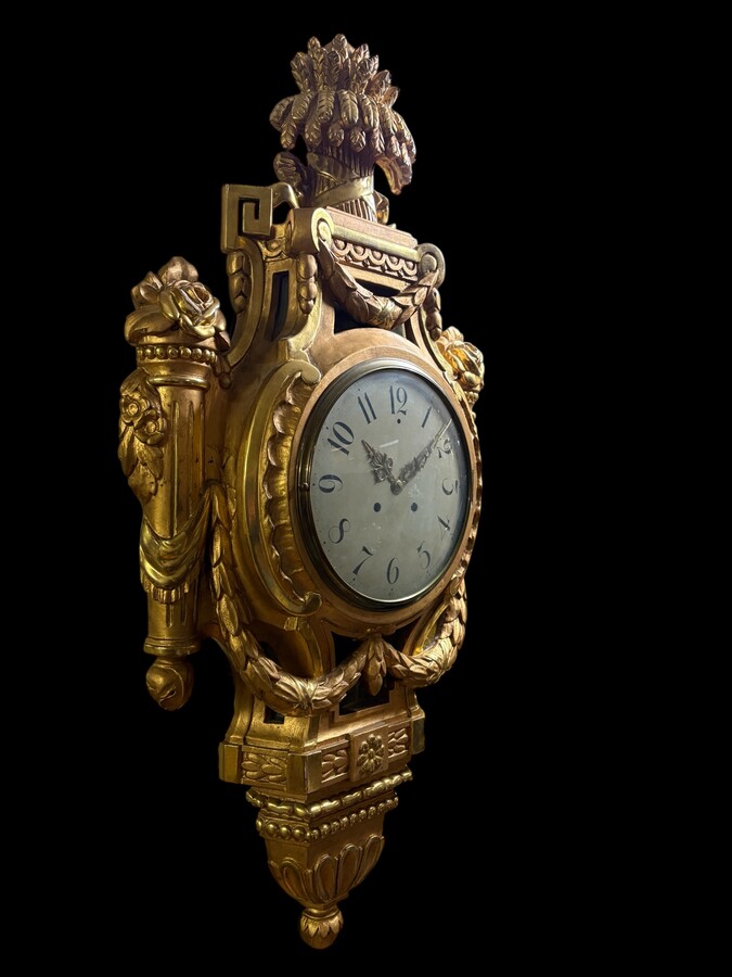 Large Swedish clock in gilded wood, Louis XVI style, 19th century Highly decorative clock in matt and shiny gold. Dimensions: Height: 97 cm Width: 49 cm Depth: 13 cm Key and pendulum present, mechanism to be checked. Attractive Swedish clock, circa 1860-1