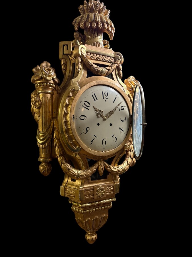 Large Swedish clock in gilded wood, Louis XVI style, 19th century Highly decorative clock in matt and shiny gold. Dimensions: Height: 97 cm Width: 49 cm Depth: 13 cm Key and pendulum present, mechanism to be checked. Attractive Swedish clock, circa 1860-1
