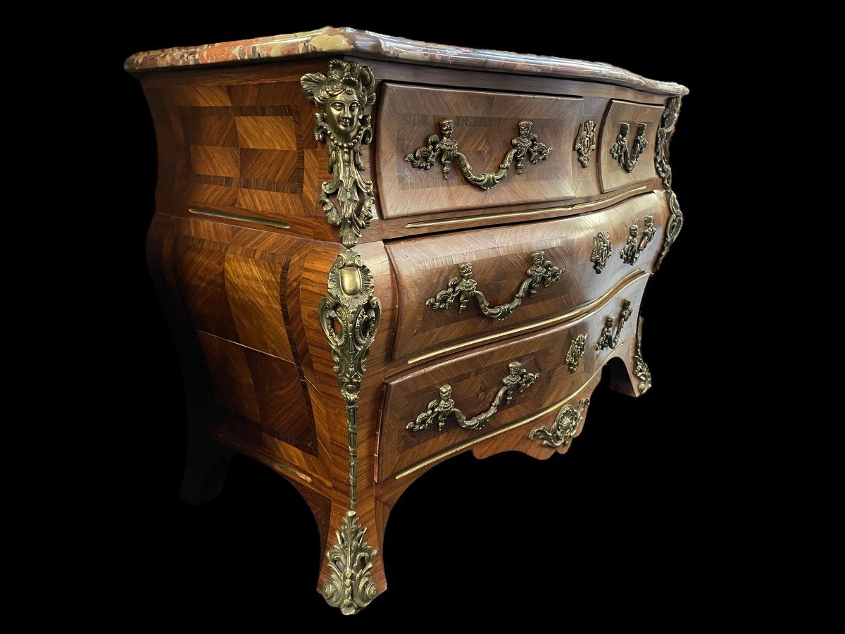 Lovely commode in Louis XV style, 20th century. Louis XV-style commode, 20th century, veneered with violet and rosewood. Curved front and sides Beautiful ornaments in gilt bronze Breche d'Alep marble top. Dimensions : Width : 129 cm Height : 87 cm 