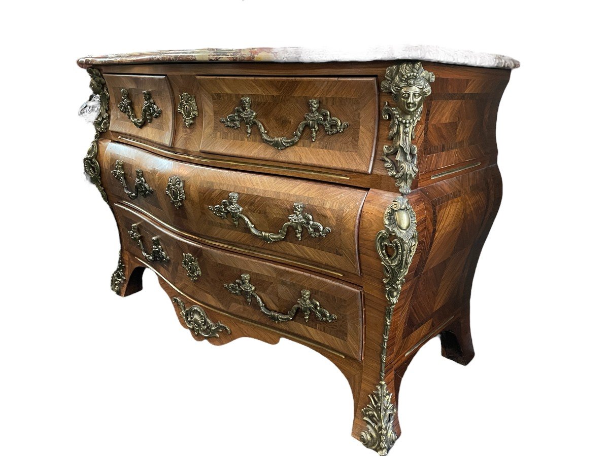 Lovely commode in Louis XV style, 20th century. Louis XV-style commode, 20th century, veneered with violet and rosewood. Curved front and sides Beautiful ornaments in gilt bronze Breche d'Alep marble top. Dimensions : Width : 129 cm Height : 87 cm 