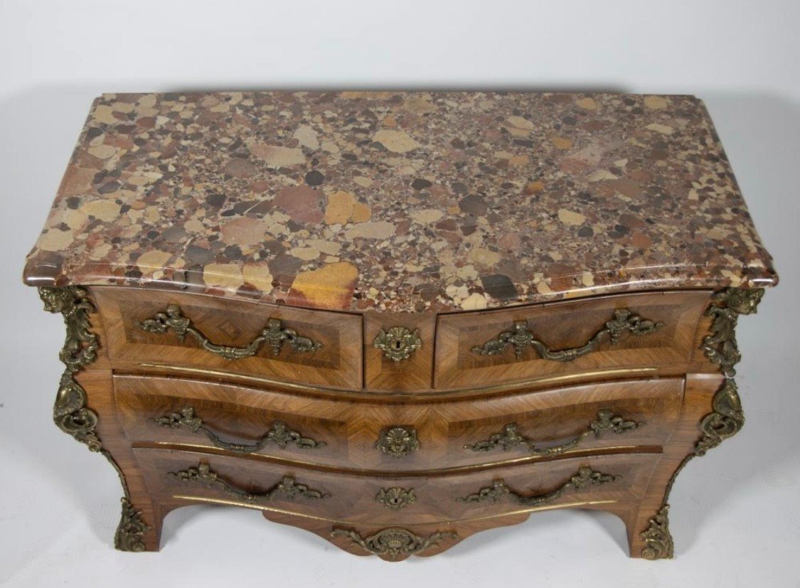 Lovely commode in Louis XV style, 20th century. Louis XV-style commode, 20th century, veneered with violet and rosewood. Curved front and sides Beautiful ornaments in gilt bronze Breche d'Alep marble top. Dimensions : Width : 129 cm Height : 87 cm
